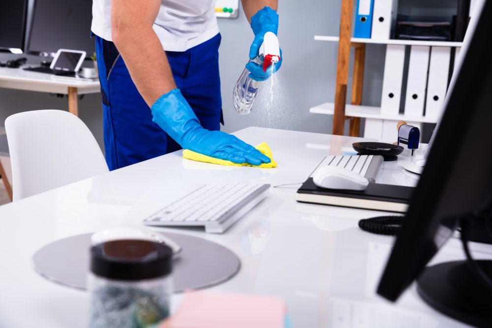 6 janitor cleaning white desk in office